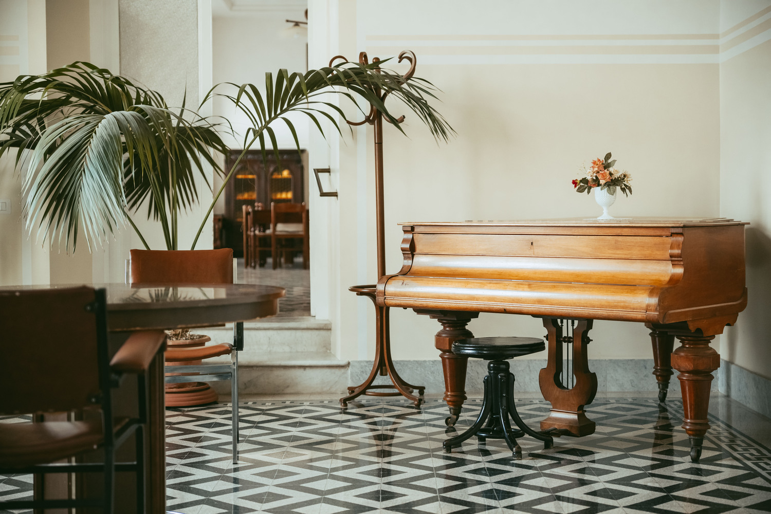 Sala comune elegante con pianoforte e tavoli