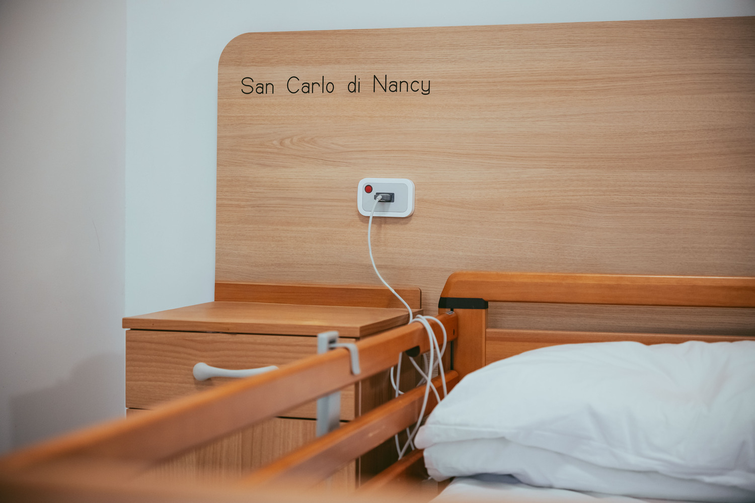 Camera singola con testiera in legno e letto assistito